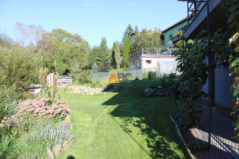 Der Garten beim Einfamilienhaus in der Lipová-Straße in Lukavica, umgeben von Grün und Blumen.
