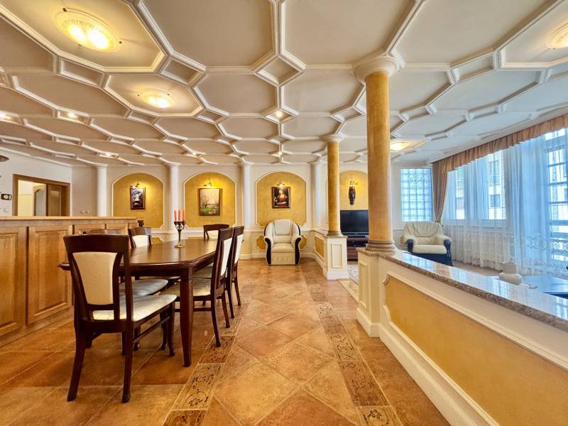 Innenraum einer 4-Zimmer-Wohnung mit eleganter Decke, Säulen und geräumigem Essbereich.