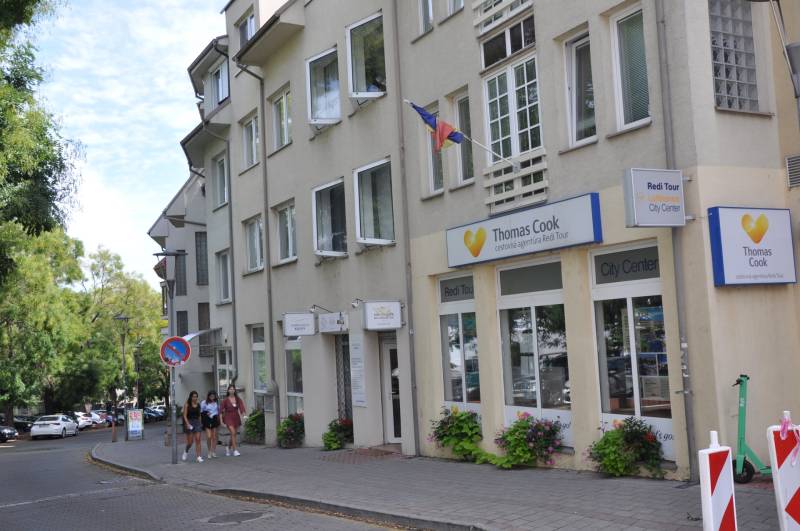 Ein Bürogebäude eines Reisebüros in der Zámocká-Straße in Bratislava, eine Gruppe von Personen auf dem Gehweg.