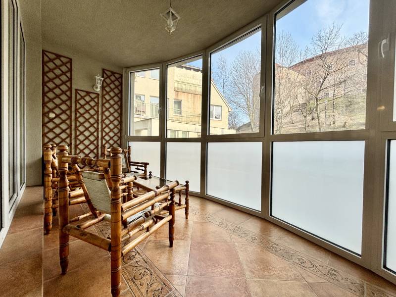 Eine typische Wintergartenwohnung mit vier Zimmern, Rattanmöbeln und großen Fenstern.