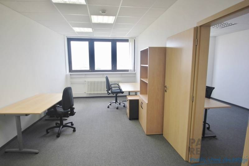 Büros mit Büromöbeln, grauem Teppichboden und heller Wand, bereit für die Arbeit.