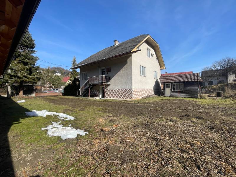 Ein Einfamilienhaus in Terchová mit einem großen Hof und einem Unterstand, umgeben von Gras und Bäumen.