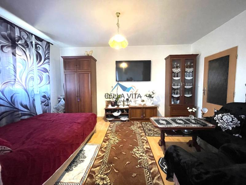 Wohnzimmer in einer Einzimmerwohnung mit Holzboden und Möbeln.