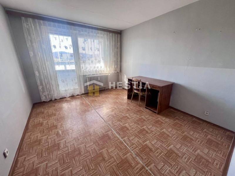 Ein Zimmer in einer 3-Zimmer-Wohnung mit einem Holzboden und großen Fenstern.