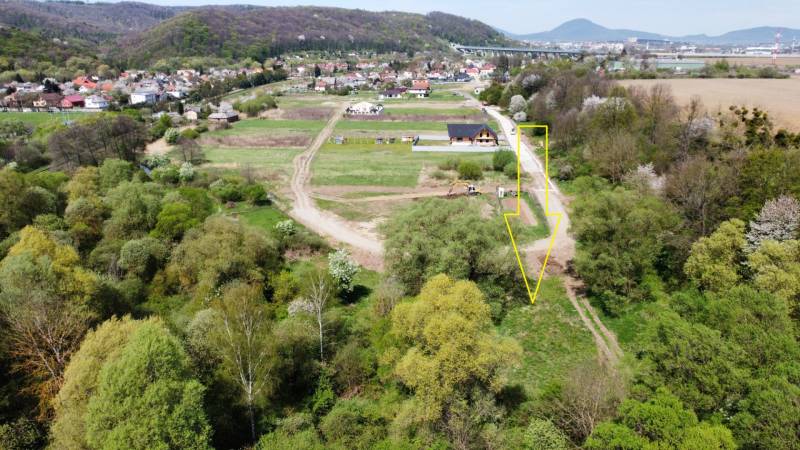 Luftaufnahme von Grundstücken in Haniska, umgeben von Grünflächen und Verkehrsinfrastruktur.