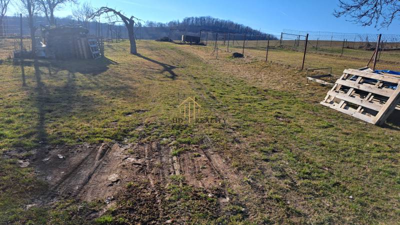Ein weitläufiger Hof mit Holzpaletten in der Nähe einer Hütte bei Kráľovce Krnišov.