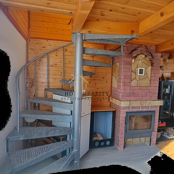 Wendeltreppe, Holzwände und Kamin im Chalet schaffen ein gemütliches Interieur.