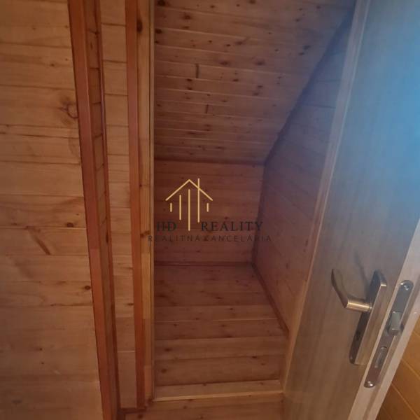 Innenraum aus Holz in einer Hütte mit Holzdekor und Treppe.