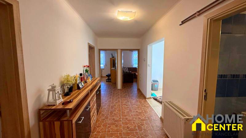 Der Flur in einem Einfamilienhaus mit Fliesen und einem Holzdekor-Schrank.