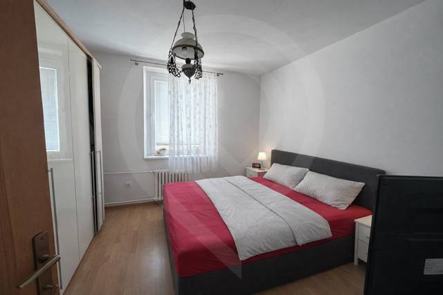 Schlafzimmer mit Bett und Schrank, Boden mit Holzdekor, 3-Zimmer-Wohnung.