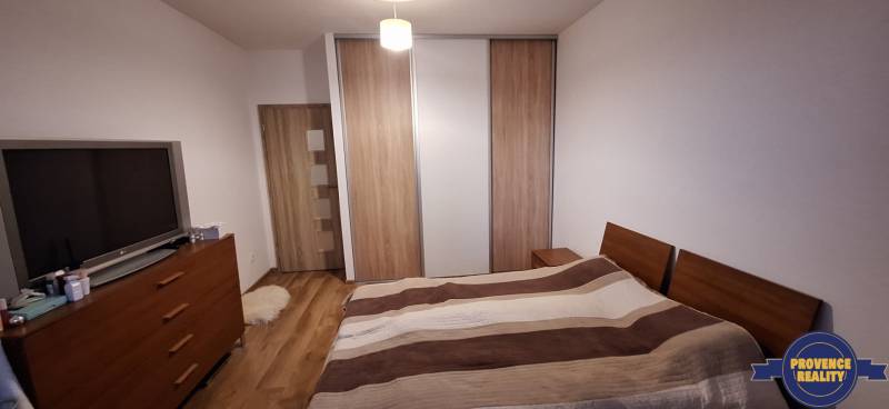 Schlafzimmer in einer 4-Zimmer-Wohnung mit Holzboden und einem großen Schrank.