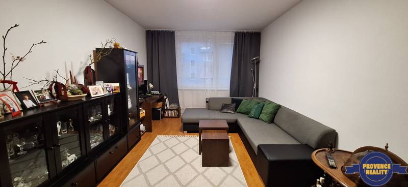 Wohnzimmer in einer 4-Zimmer-Wohnung mit Holzboden und bequemen Sitzgelegenheiten.