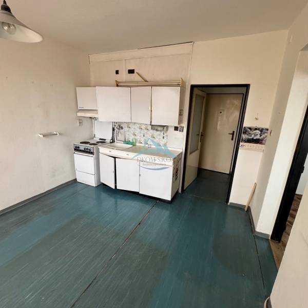 Küchenzeile in einer Einzimmerwohnung mit Holzboden.