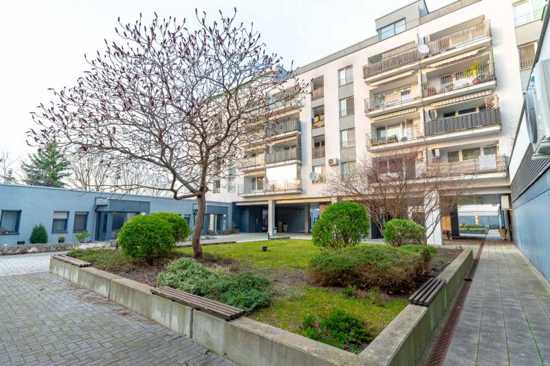 Wohnhaus an der Hrachova in Bratislava - Ružinov, umgeben von Grün mit Bäumen und Sträuchern.