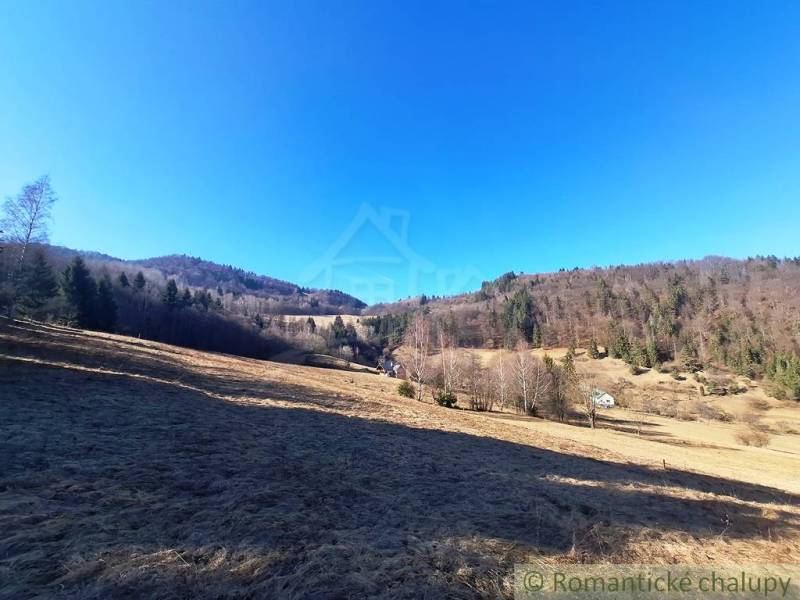 Weitläufige landwirtschaftliche und forstwirtschaftliche Flächen in der Umgebung von Hronec, umgeben von Wäldern und Hügeln.
