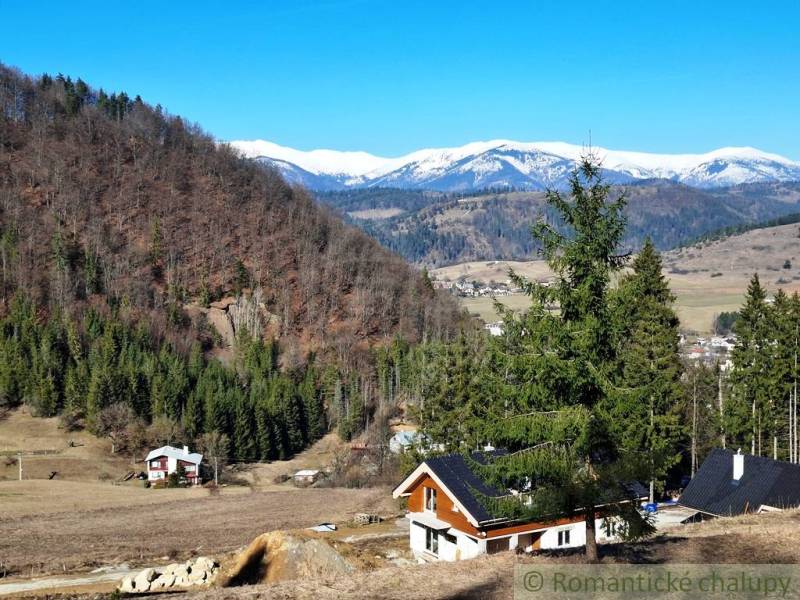 Verschneite Berge und Hütten, umgeben von Wäldern und landwirtschaftlichen Flächen bei Hronec.