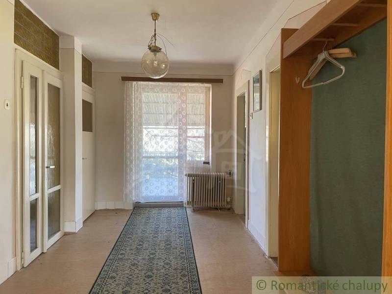 Innenraum eines Einfamilienhauses mit Holzboden, Vorhang und Teppich.