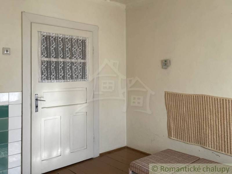 Innenraum eines Einfamilienhauses mit weißen Türen, Wandverkleidung und Bodenbelag in Holzoptik.