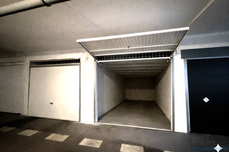 Offene Garage mit leerem Innenraum und weißen Wänden.