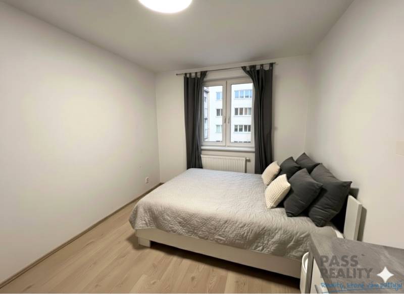 Schlafzimmer mit Bett und Holzboden in einer 2-Zimmer-Wohnung.