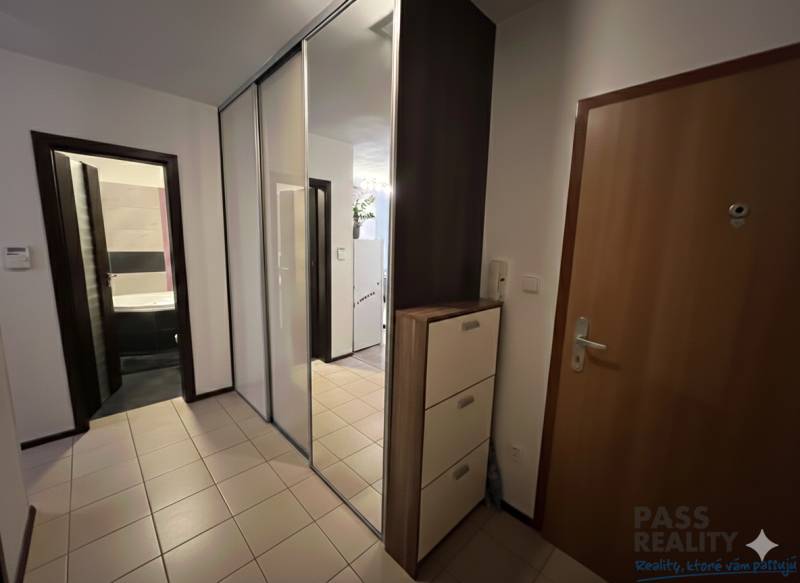 Eingangshalle in einer 2-Zimmer-Wohnung mit Fliesen, großem Spiegel und Schränken.