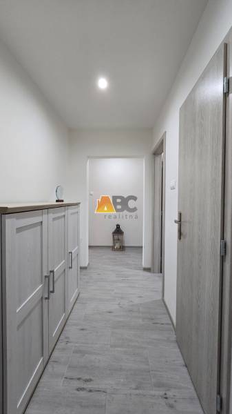 Der Flur mit einem Holzboden in einer Zweizimmerwohnung, Möbel auf der linken Seite.