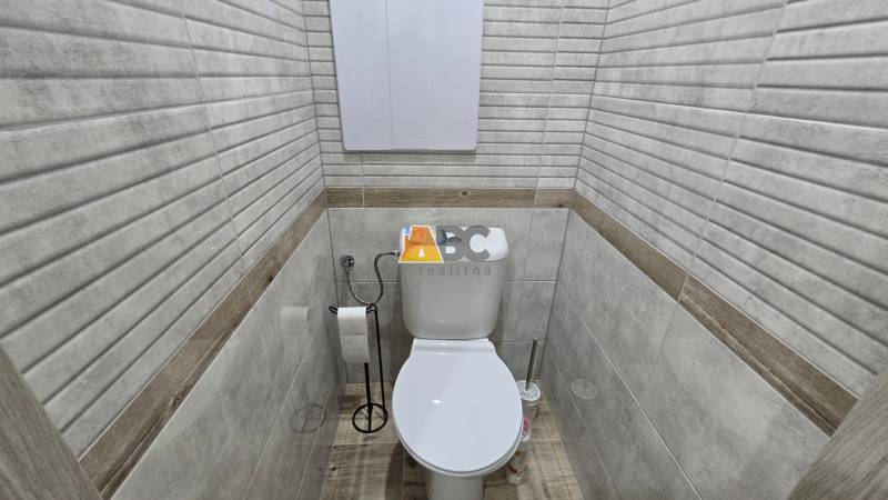 Badezimmer aus einer 2-Zimmer-Wohnung mit Toilette und Boden in Holzoptik.