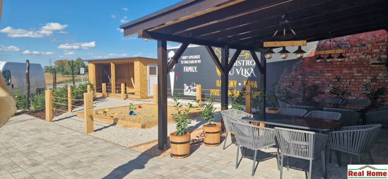 Außenbereich in Nová Dedinka mit Gastronomieräumen, Terrasse und Kinderspielplatz.