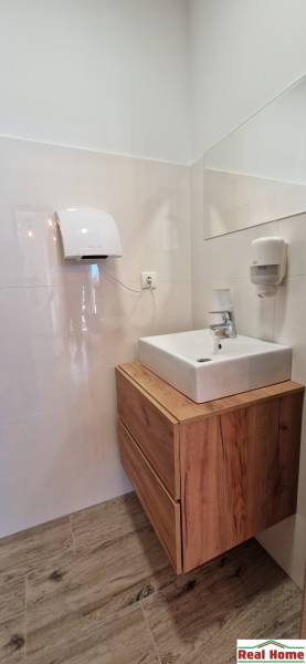 Badezimmer mit Waschbecken und Schrank mit Holzdekor in Gastronomiebereichen.