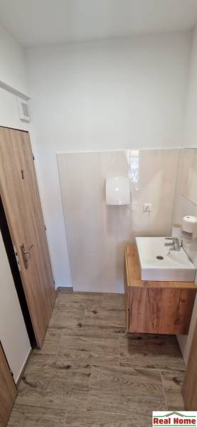 Badezimmer mit Waschbecken und Boden in Holzoptik in Gastronomiebereichen.