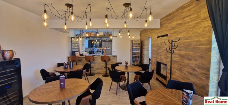 Gastronomiebereiche mit Holzboden und hängenden Glühbirnen.