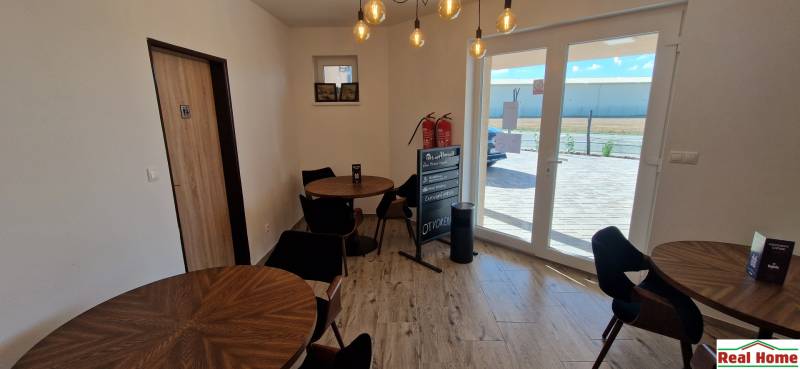 Innenraum von Gastronomiebereichen mit Holzdekor und einem Fenster, das einen Ausblick nach draußen bietet.