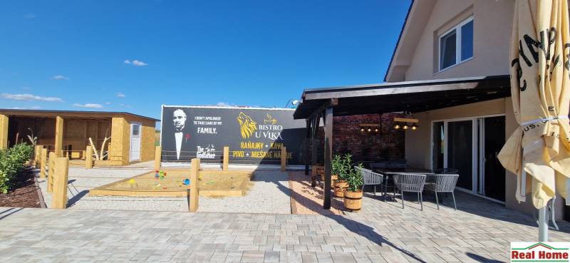 Gastronomiebereiche in Nová Dedinka mit Terrasse, Sandkasten und thematischem Ausblick.