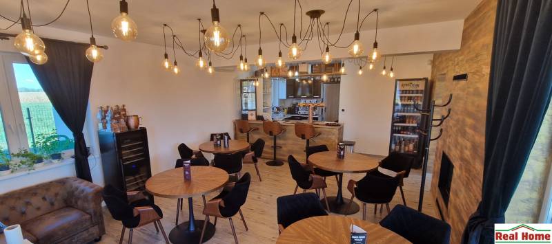 Innenraum von Gastronomiebereichen mit Holzboden und Glühbirnenbeleuchtung.