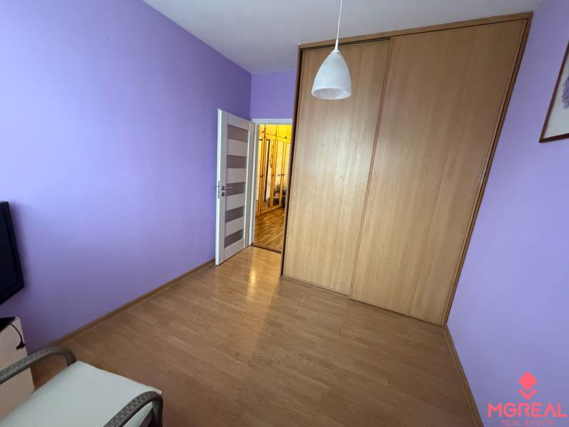 Lila Wände, Einbauschrank und Boden mit Holzdekor in einer 3-Zimmer-Wohnung.