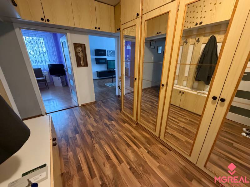 Eingangsbereich in einer 3-Zimmer-Wohnung mit Holzboden und Spiegelschränken.