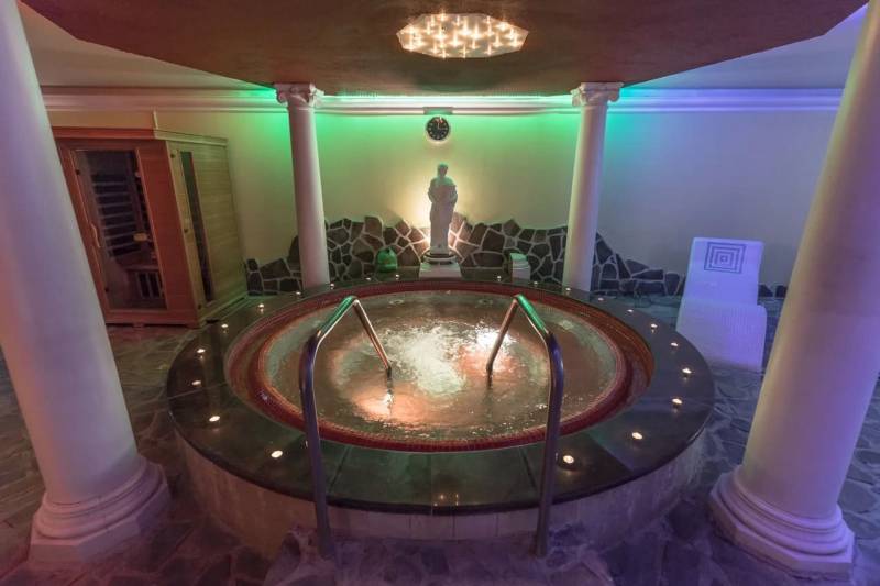 Entspannungsraum mit Whirlpool, Sauna und Skulptur in der Ferienwohnung.