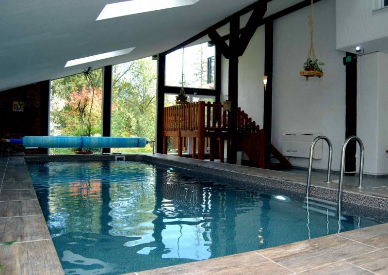 Innenraum einer Ferienwohnung mit Holzboden und überdachtem Pool.