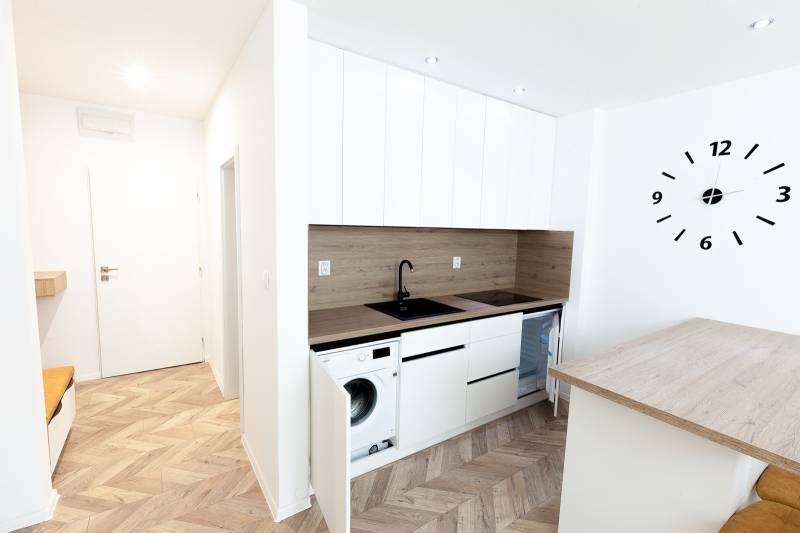 Eine modern eingerichtete Küche mit Holzboden in einem Ferienapartment.