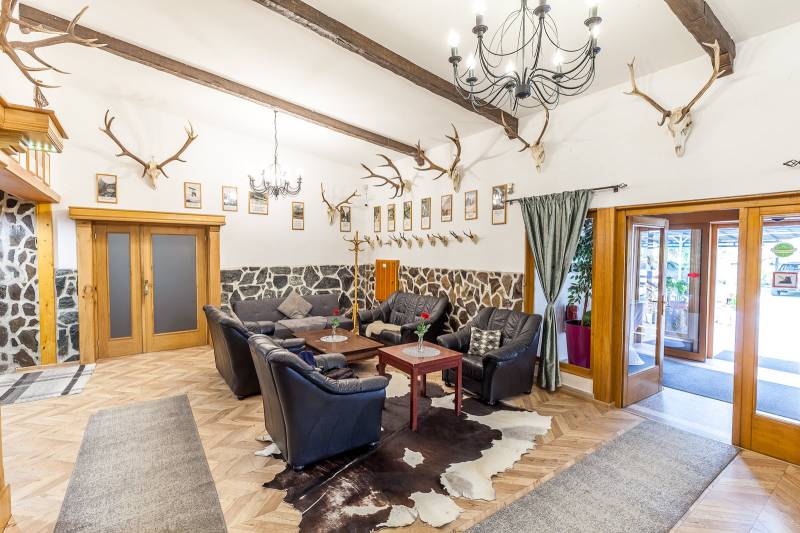 Innenraum einer Ferienwohnung mit Ledersofa, Ecken und Boden in Holzoptik.