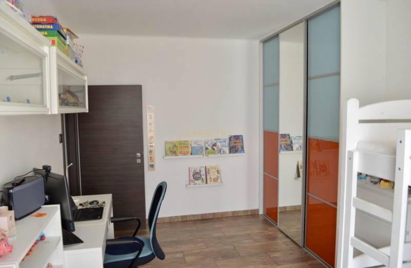 Kinderzimmer in einer 2-Zimmer-Wohnung mit Schreibtisch, Etagenbett und Einbauschrank.