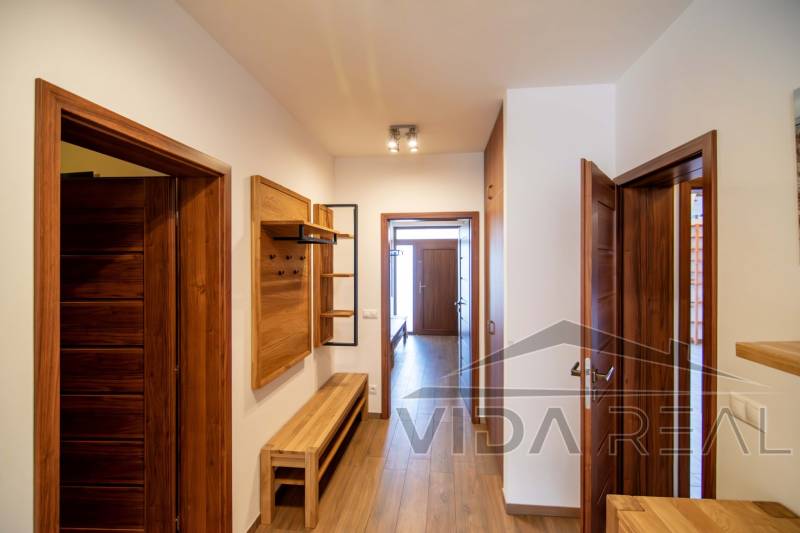 Flur in einem Einfamilienhaus mit Holzdekor auf dem Boden und Möbeln.