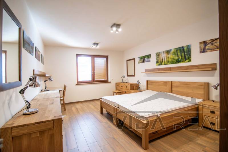 Schlafzimmer mit Holzmöbeln und Bodenbelag in Holzoptik im Einfamilienhaus.