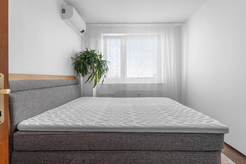 Schlafzimmer mit Klimaanlage und Bett in einer 4-Zimmer-Wohnung.