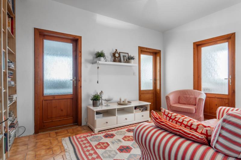 Wohnzimmer in einer 4-Zimmer-Wohnung mit rot gestreiften Sesseln und einem Regal an der Wand.