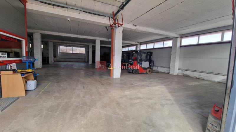 Innenräume von Lagern und Hallen mit hohen Decken und Arbeitsgeräten, einschließlich Gabelstapler.