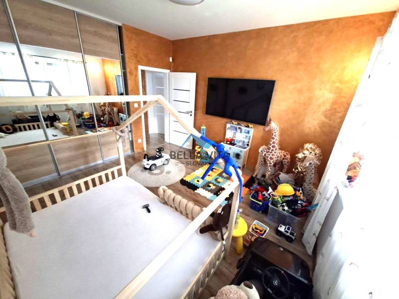 Kinderzimmer in einem Einfamilienhaus mit Spielzeug, Bett und Schränken. Boden mit Holzdekor.