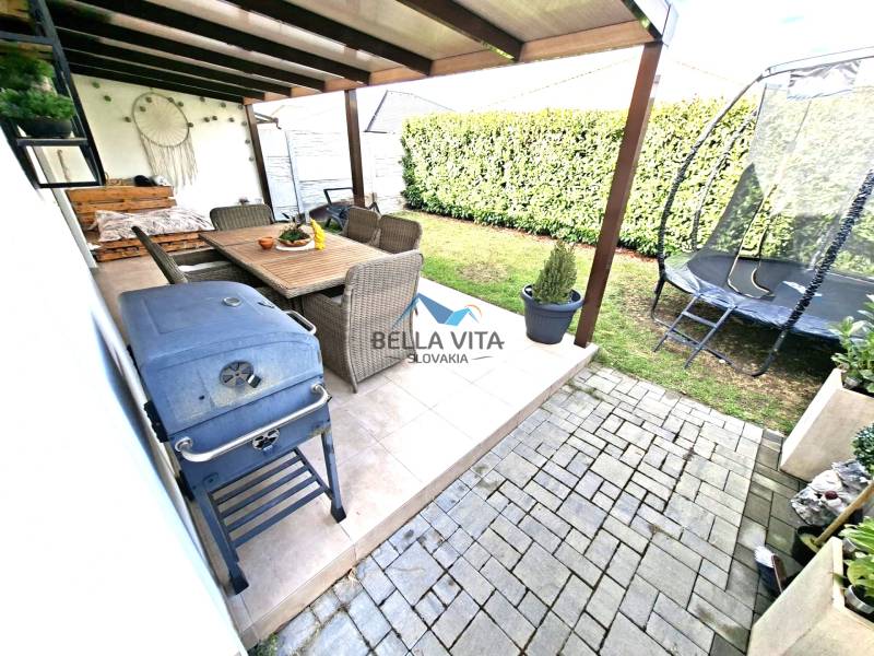 Garten des Einfamilienhauses in der Mládežnícka-Straße in Galanta: Terrasse, Trampolin, Grill, Sitzgelegenheit.