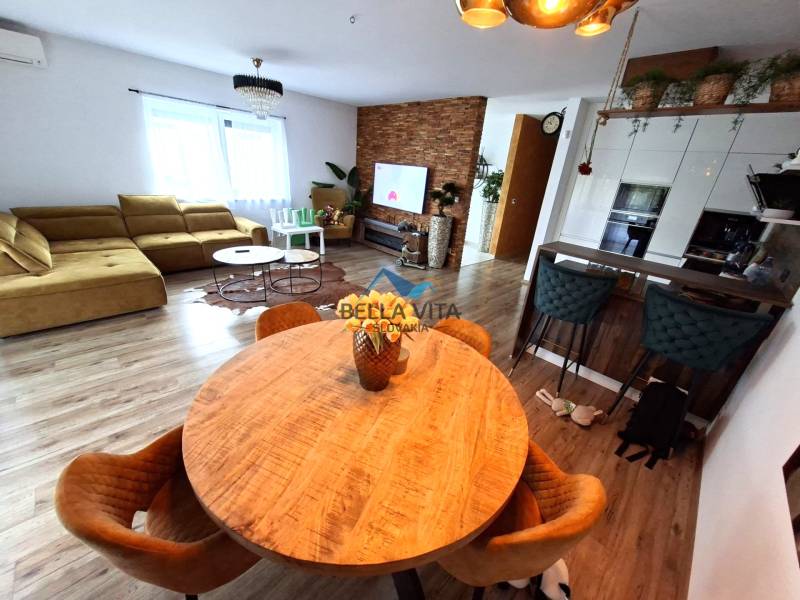 Wohnzimmer in einem Einfamilienhaus mit Sofa, Esstisch und Holzboden.