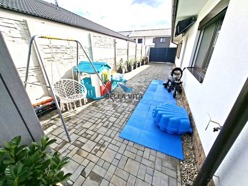 Hof beim Einfamilienhaus in der Mládežnícka-Straße in Galanta mit einem Kinderspielplatz und einer Schaukel.